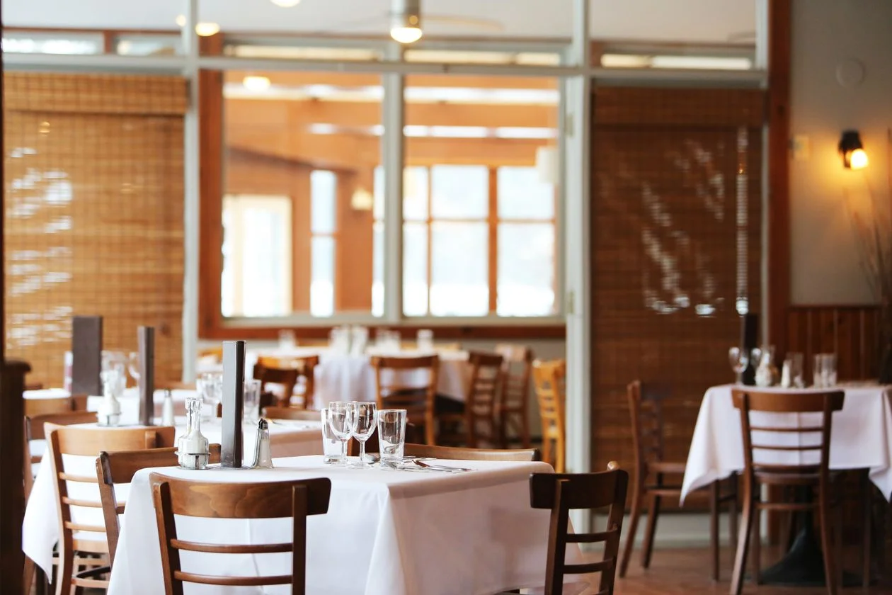 A dining room with tables set for a gathering